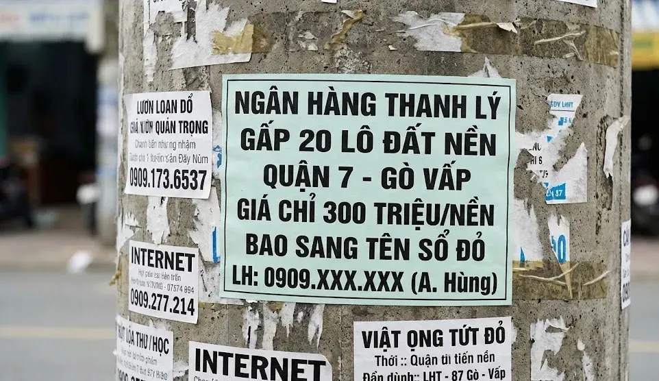 Hình ảnh thực tế một tờ rơi quảng cáo lừa đảo "Ngân hàng thanh lý gấp đất nền giá rẻ 300 triệu" dán trên cột điện.